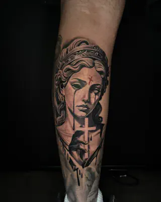 Black and grey realism portrait of a crowned woman with a cross beneath her face, on a calf