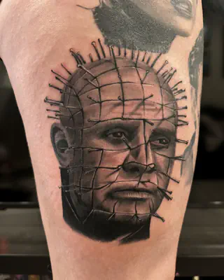 Black and grey realism portrait of Pinhead from Hellraiser, on a forearm