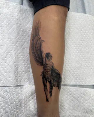 Black and grey tattoo of a winged figure in flight, on a forearm