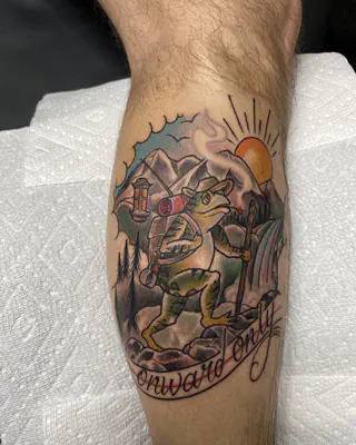 Color tattoo of a frog adventurer with a walking stick in a mountain landscape above an Onward Only banner, on a calf