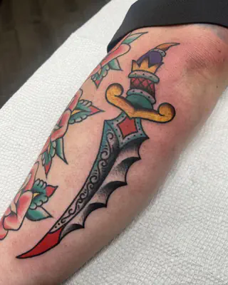 Traditional color dagger with a curved, bat-wing blade, on a forearm