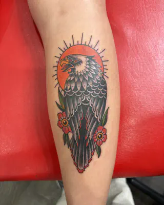 American traditional eagle in front of a red sun, with two red flowers, on a calf