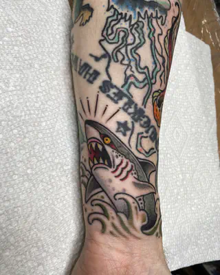 American traditional color shark bursting from waves, part of a forearm patchwork